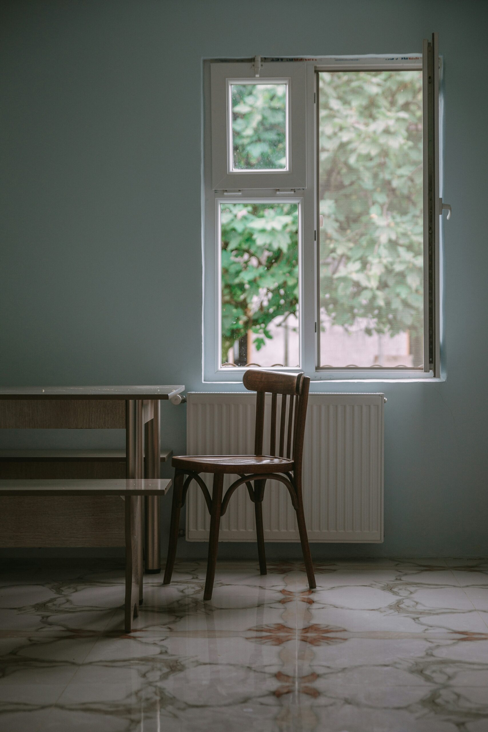 Image of a table and chair next to a window.